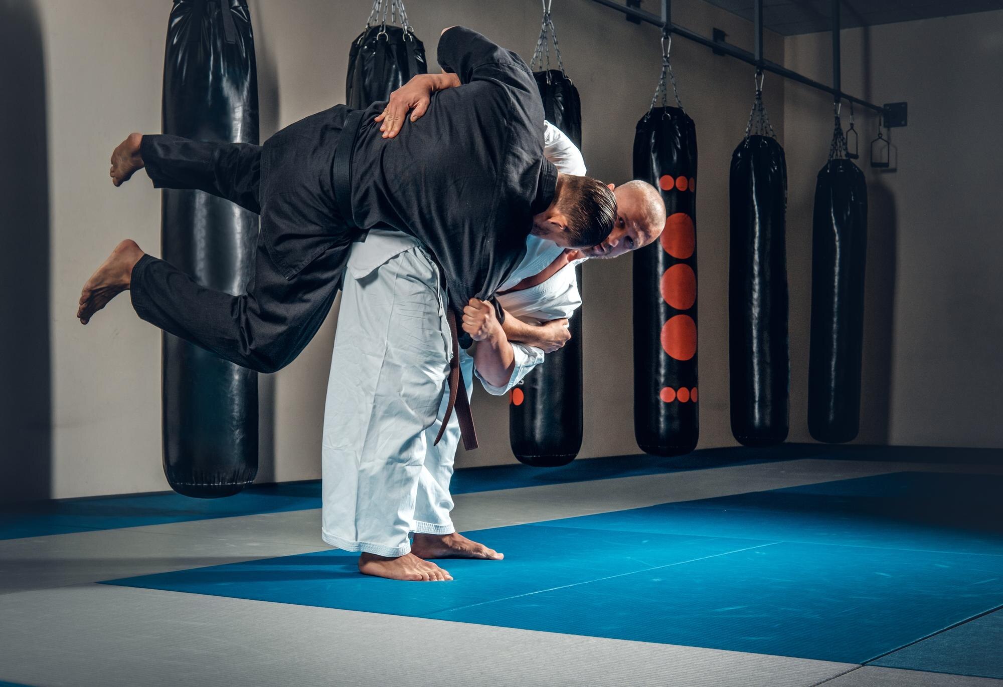 Practicantes de Jiu-Jitsu en tatami azul — gestión de alumnos BJJ con Kizami